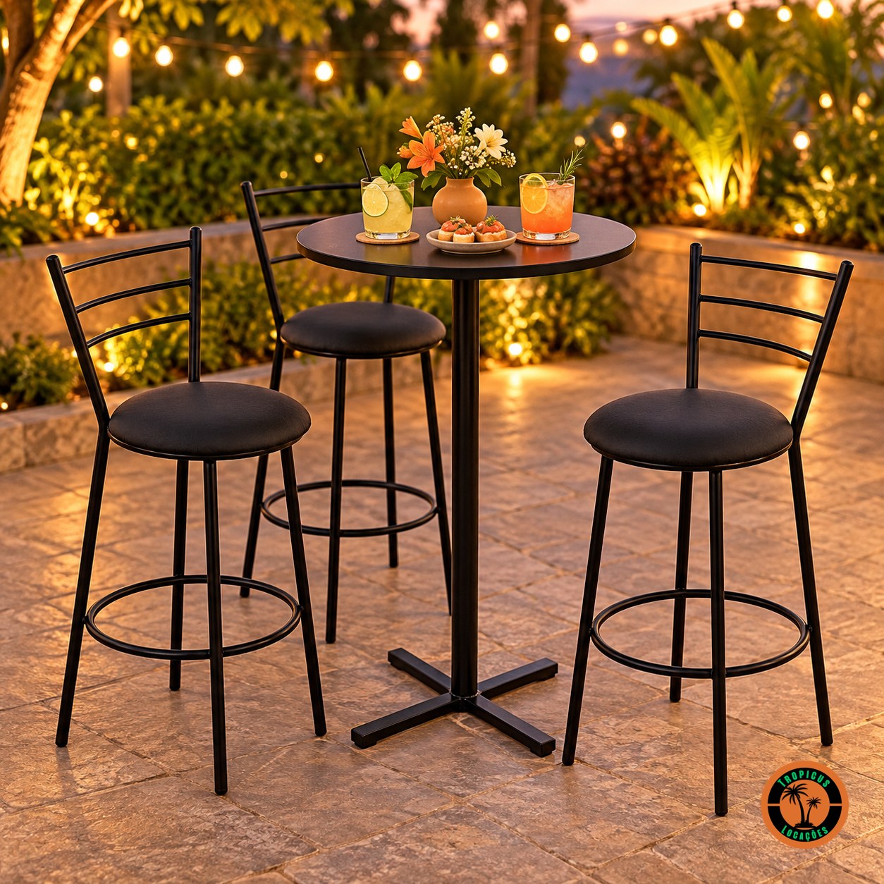 Três banquetas bistrô altas pretas em volta da mesa bistrô alta preta num terraço ao entardecer, com drinks e petiscos