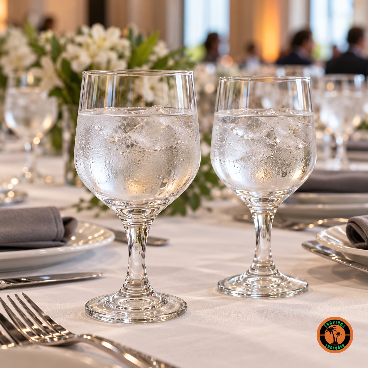 Mesa de evento corporativo com taças Água Bistrô servidas com água e gelo e guardanapo cinza