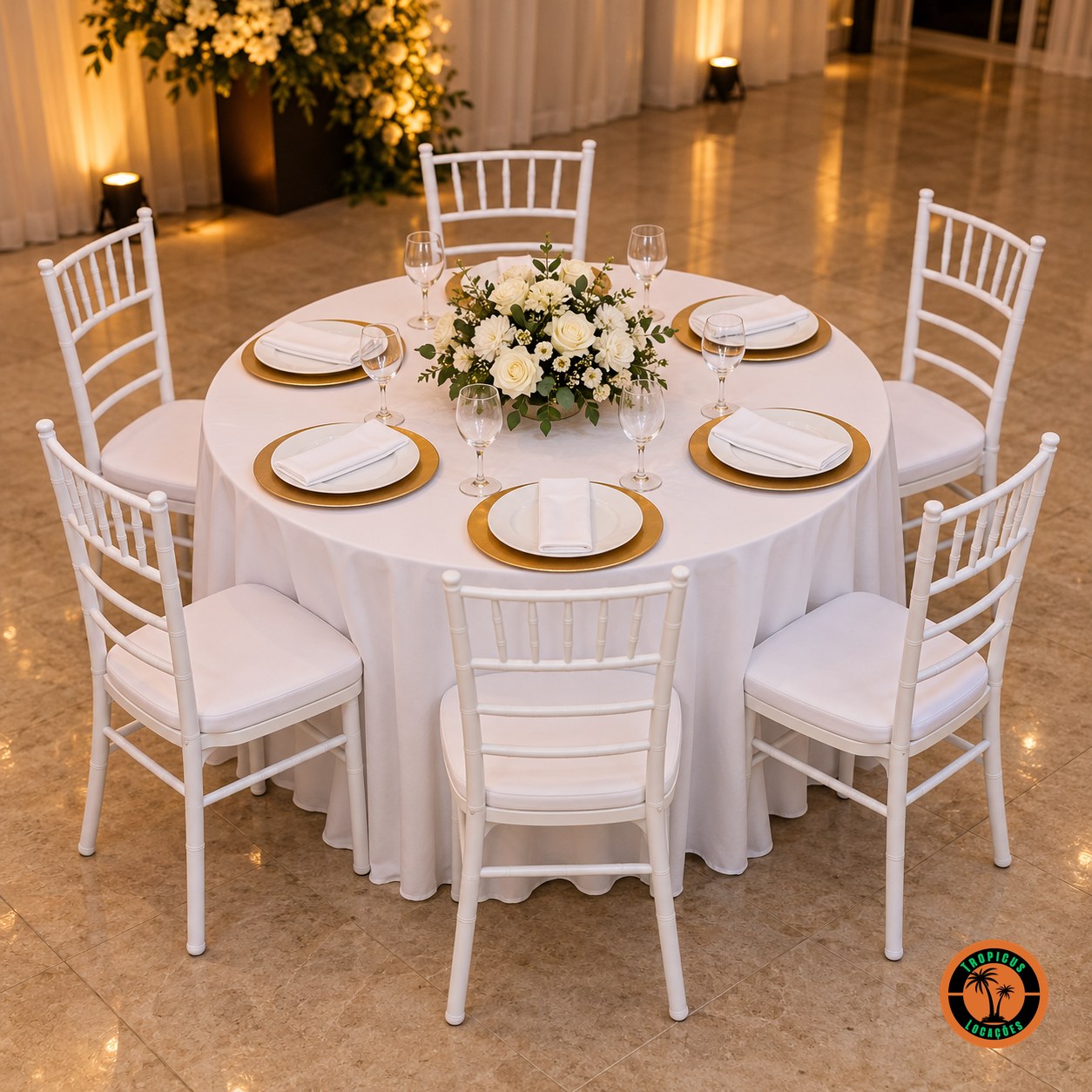 Mesa redonda de casamento para 6 lugares com o tampão de 1,20 m, toalha branca, sousplats dourados e cadeiras Tiffany brancas