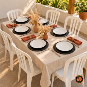 Mesa com sousplats escamados preto, guardanapos terracota e cadeiras plásticas brancas