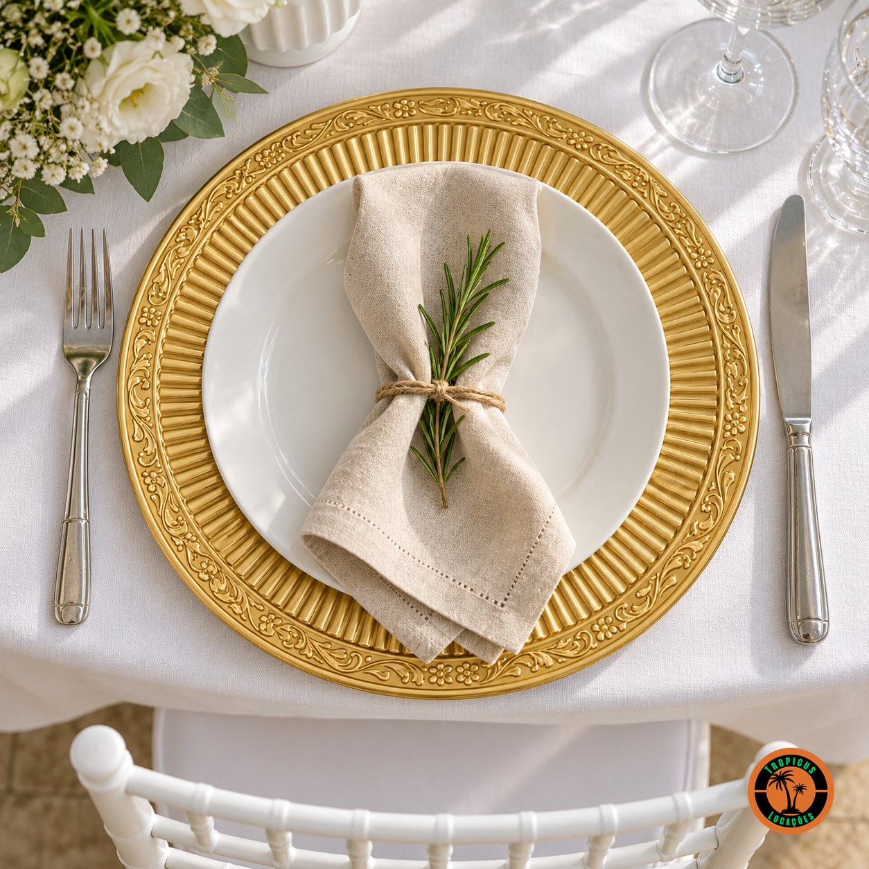 Sousplat dourado com frisos sob prato branco e guardanapo de linho