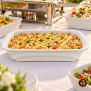 Arroz de forno no refratário retangular de louça branca em mesa de buffet