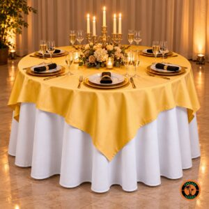 Mesa redonda com cobre-mancha amarelo-ouro sobre toalha branca, candelabro com velas