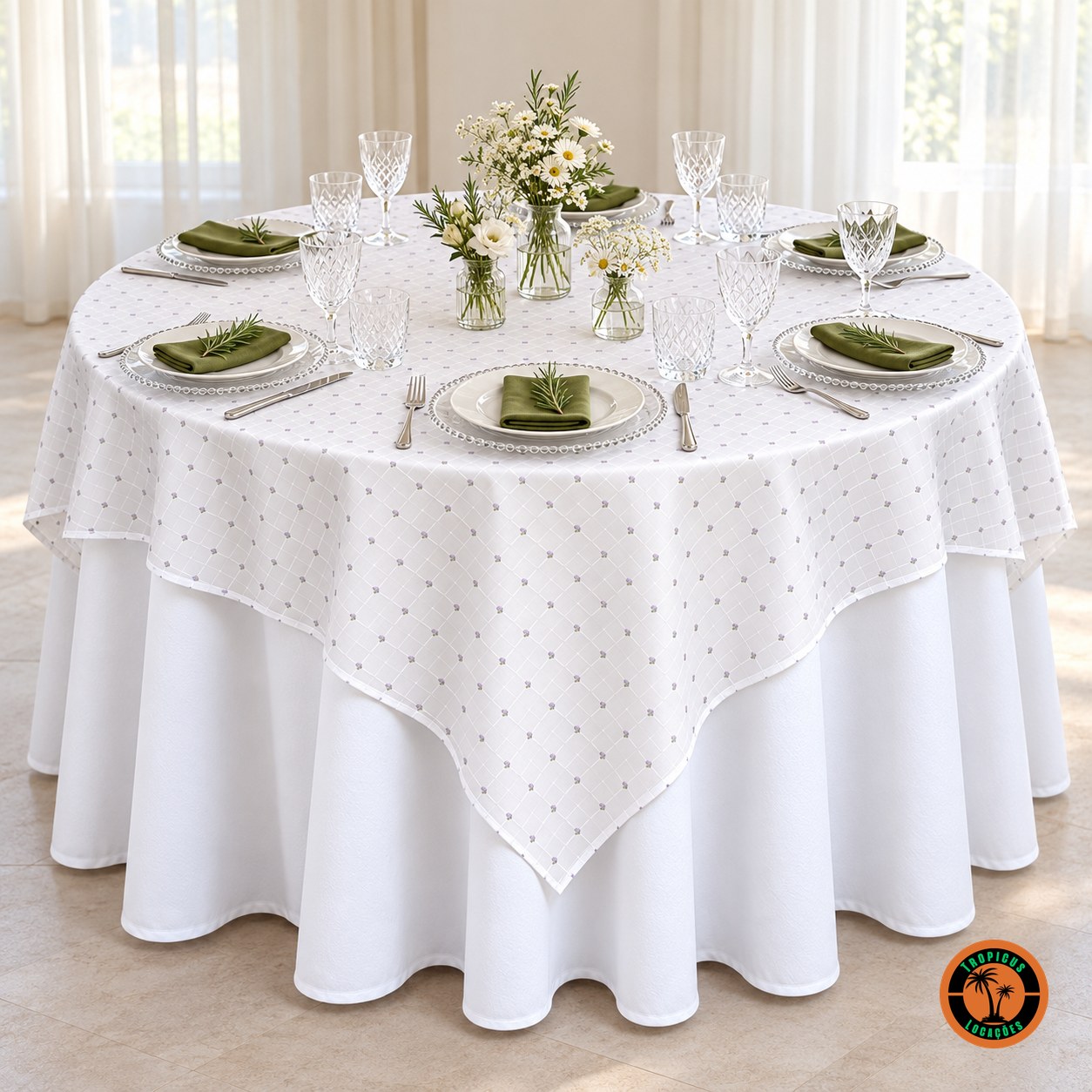 Mesa redonda com cobre-mancha branco de florzinhas lilás, sousplats de vidro e flores do campo