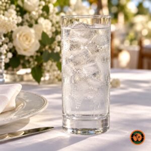 Copo Long Drink com água e gelo numa mesa posta de casamento com toalha branca