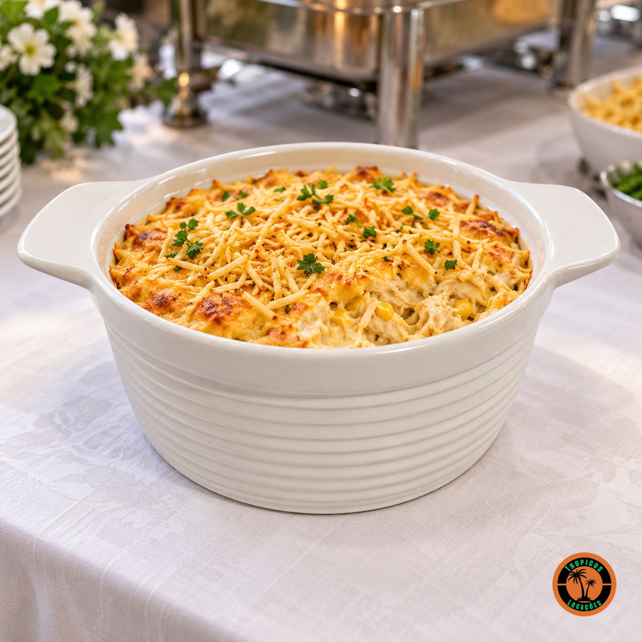 Fricassê gratinado no refratário redondo de louça branca em mesa de buffet