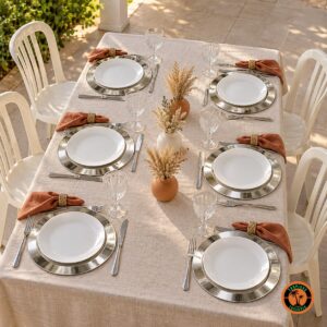 Mesa com sousplats de alumínio, guardanapos terracota e cadeiras plásticas brancas