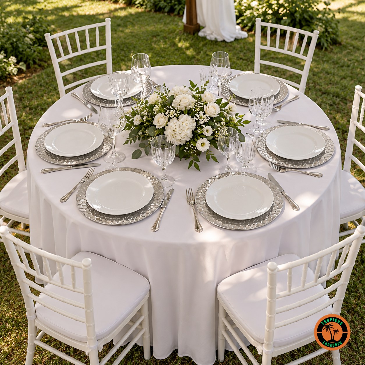 Mesa redonda de casamento com sousplats escamados prata e cadeiras Tiffany brancas